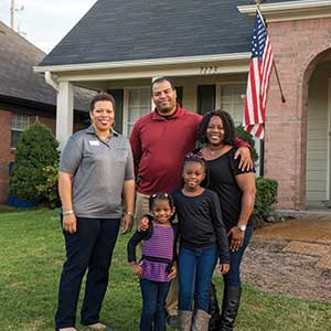 A family poses in front of their new home 